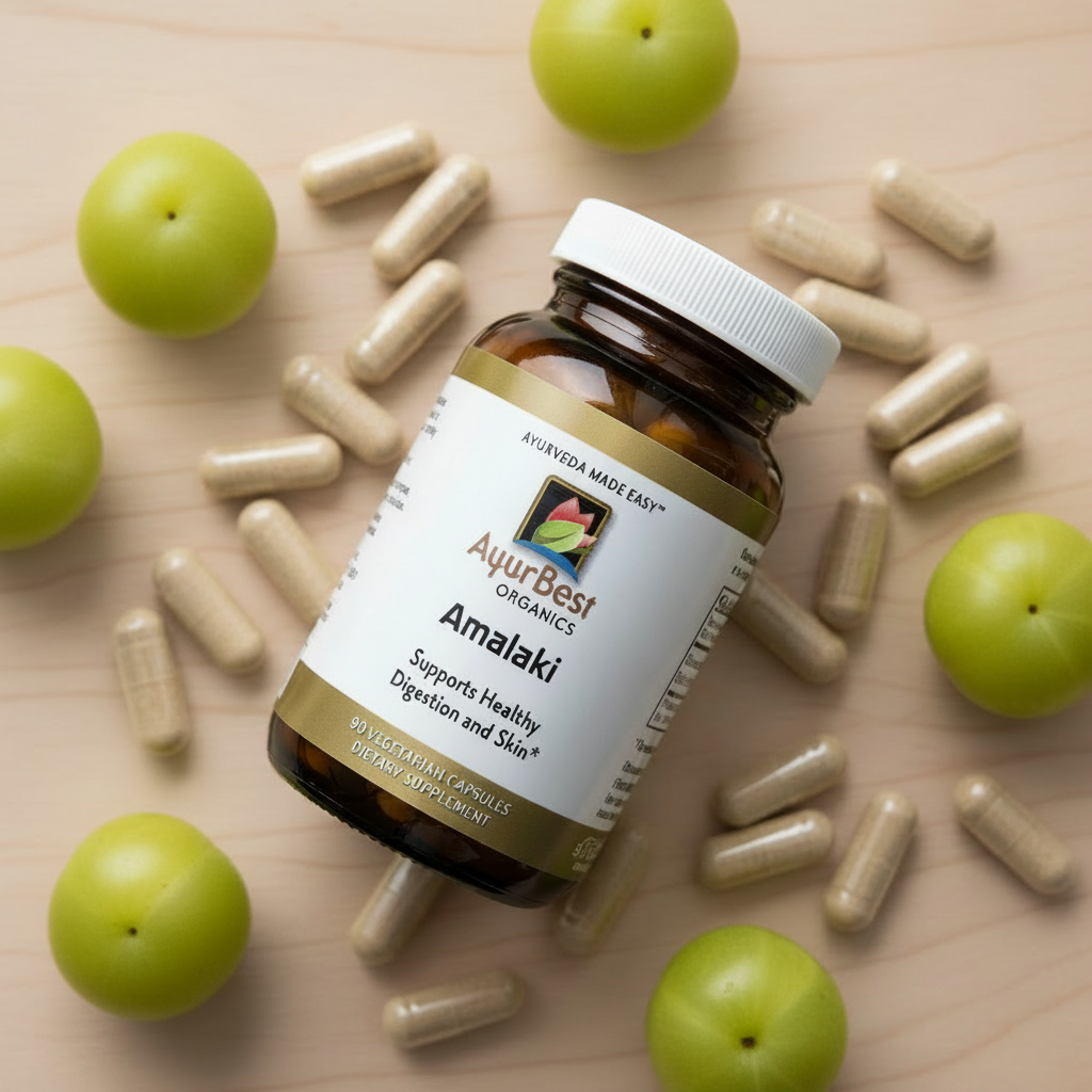 Ayurvedic Amalaki supplement bottle with capsules and amalaki fruits on a wooden surface