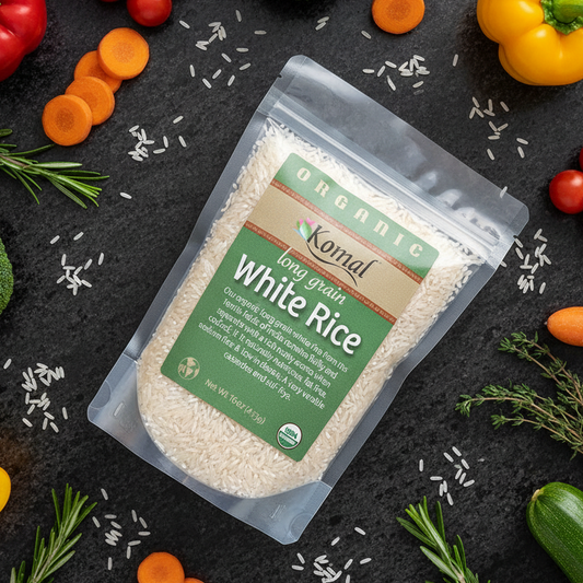 Komal White Rice package surrounded by vegetables on a dark surface