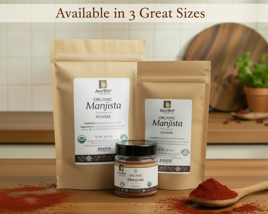 Three packages of AyurBest Organic Manjista Powder on a wooden surface with a spoonful of powder and a jar.