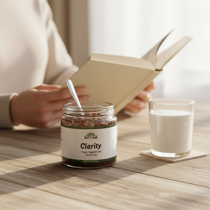 Person reading a book with a jar labeled 'Clarity' and a glass of milk on a wooden table.
