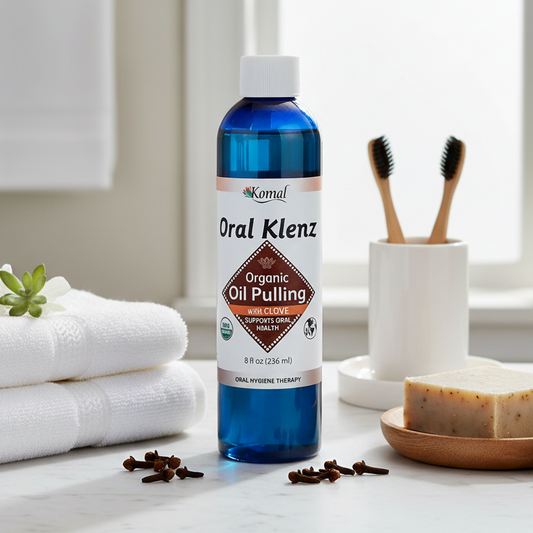 Bottle of Oral Klenz Organic Oil Pulling on a bathroom counter with towels and a plant in the background.