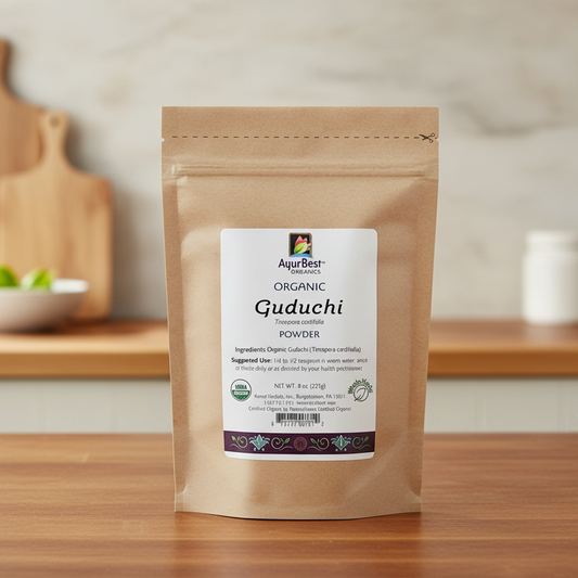 Package of AyurBest Organic Guduchi Powder on a wooden surface with a blurred kitchen background