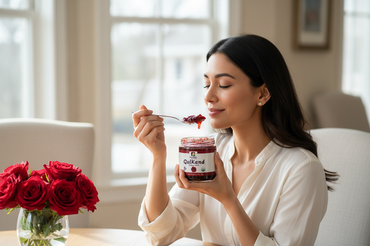 Woman eating Organic Gulkand with a spoon in a bright room with flowers on the table.