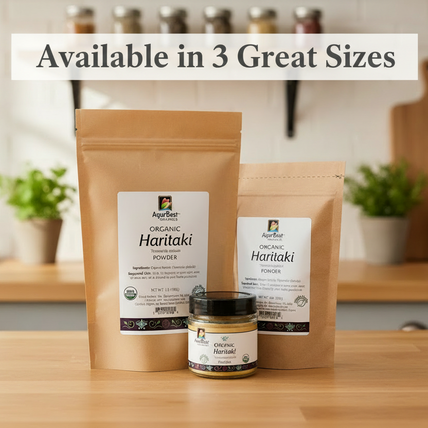 Three sizes of AyurBest Organic Haritaki Powder packaging on a wooden surface with plants in the background.