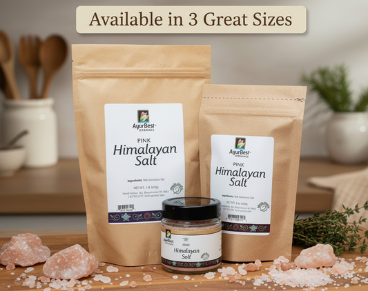 Two packages of Himalayan salt and a jar on a wooden surface with kitchen utensils in the background.
