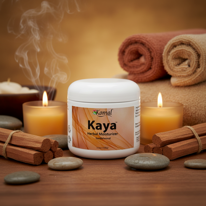 Kaya Herbal Moisturizer jar with candles, towels, and stones on a wooden surface