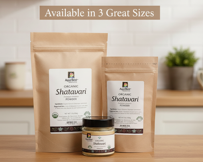 Three packages of AyurBest Organic Shatavari Powder on a wooden surface with a blurred kitchen background.