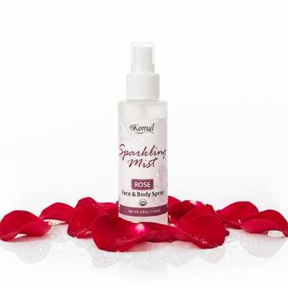 Komal Sparkling Mist Rose Face & Body Spray surrounded by red rose petals on a white background