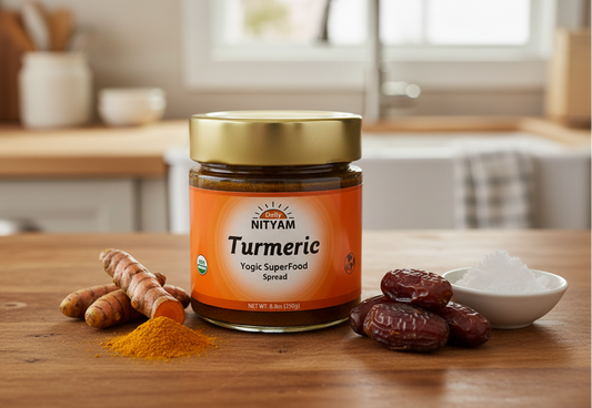 Nityam Turmeric spread jar on a wooden table with organic ingredients including turmeric roots, coconut oil, and dates.