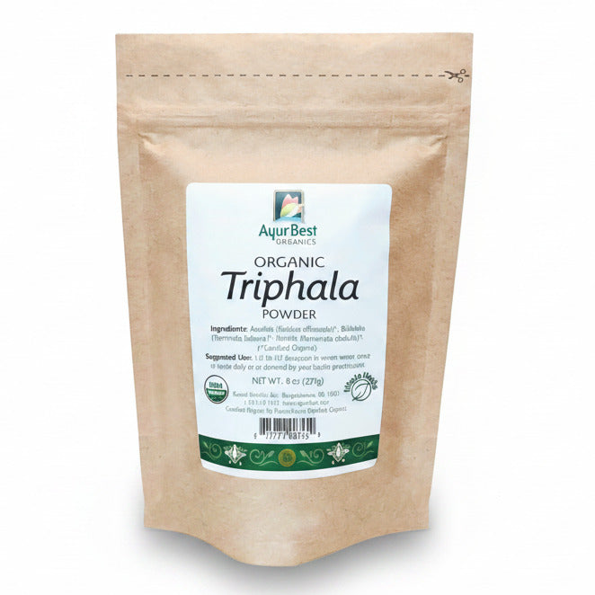 A bag of AyurBest Organic Triphala Powder, with a beige packaging and a green and white label featuring the product name and organic certification symbol.